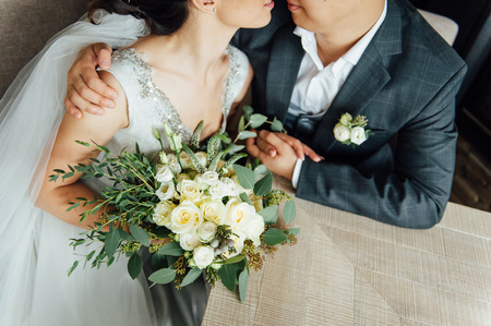 closeup of bride hands holding beautiful wedding bouquetの写真素材