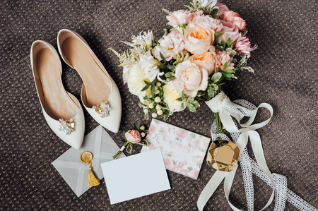 Wedding floristics and details. Wedding invitations. Bouquet of peonies and hydrangeas. Brooch. Footwear. White shoes. Wedding rings.の写真素材