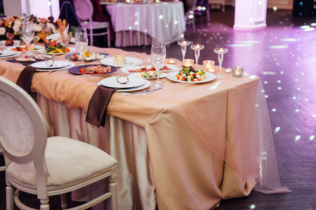 Luxury, elegant wedding reception table arrangement, floral centerpiece. with color spotlightsの写真素材