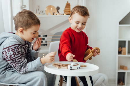 two brothers play puzzle on the table in the childrens room in the Scandinavian styleの写真素材