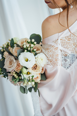 bride in a bathrobe holding her wedding bouquetの写真素材