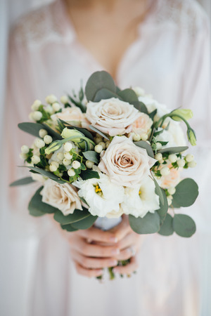bride in a bathrobe holding her wedding bouquetの写真素材