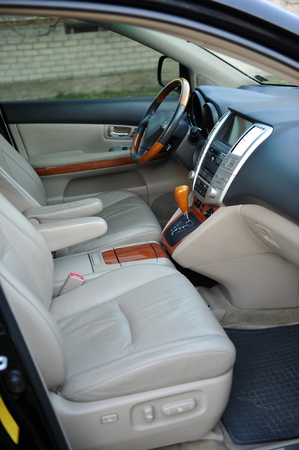 Modern luxury prestige car interior, dashboard, steering wheel. Perforated leather, wooden interior.の写真素材