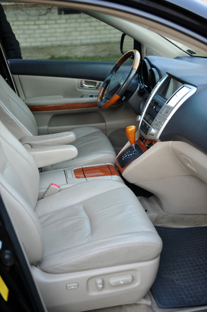 Modern luxury prestige car interior, dashboard, steering wheel. Perforated leather, wooden interior.の写真素材