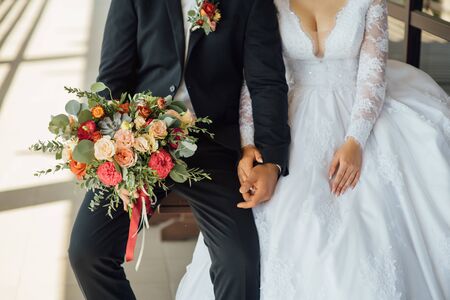 the groom waits for the bride and holds in hands a beautiful wedding bouquetの写真素材