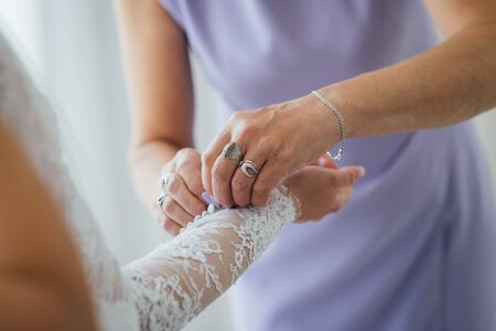 Bridesmaid preparing bride for the wedding day. Best morning. Wedding conceptの写真素材