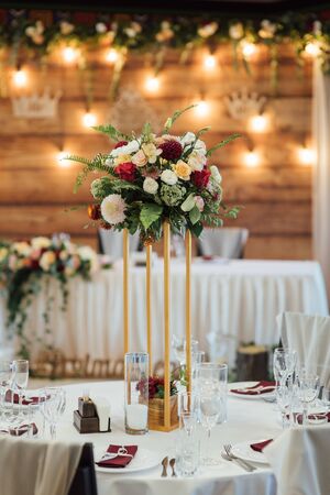 A composition of flowers and green is on a festive table at the wedding banquet hall.の写真素材