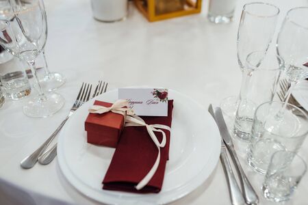 Glasses, flower fork, knife served for dinner in restaurant with cozy interiorの写真素材