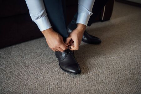 Business man tying shoe laces on the floor. Close-upの写真素材