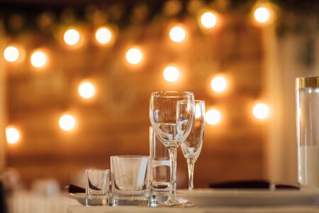 Glasses, flower fork, knife served for dinner in restaurant with cozy interiorの写真素材