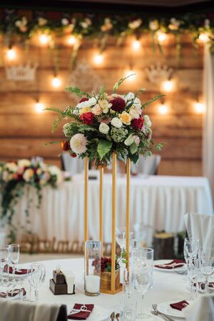 A composition of flowers and green is on a festive table at the wedding banquet hall.の写真素材