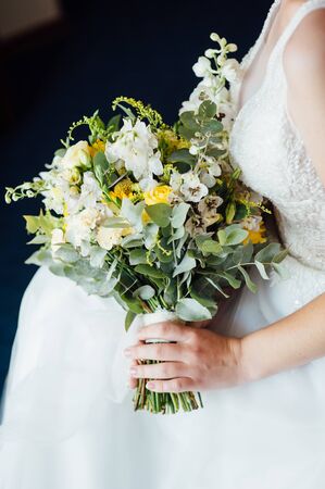 Beautiful bride is holding a wedding colorful bouquet.の写真素材