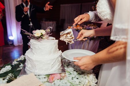 Happy bride and groom cut the cake. Evening ceremonyの写真素材