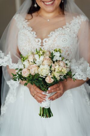 Beautiful bride is holding a wedding colorful bouquet.の写真素材