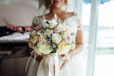 Beautiful bride is holding a wedding colorful bouquet.の写真素材