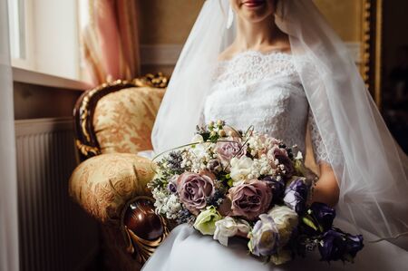 Beautiful bride is holding a wedding colorful bouquet.の写真素材