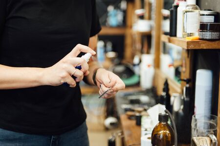 The hands of young barber making haircut to attractive man in barbershopの写真素材