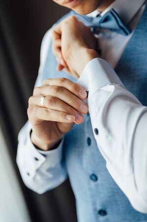Man buttons cuff link on cuffs sleeves luxury white shirt.の写真素材