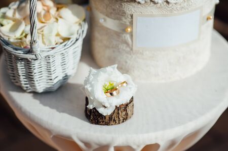 Two wedding rings with white flower in the backgroundの写真素材