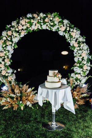 wedding cake three floors with fruit outside in the eveningの写真素材