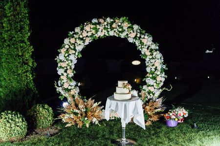wedding cake three floors with fruit outside in the eveningの写真素材