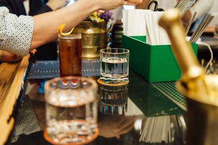 Group of friends having drinks whiskey at the night club after work . Young men drink whiskey and enjoying at a bar toasting cocktails.の写真素材