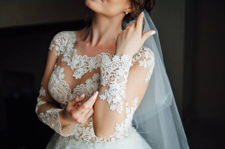 Gorgeous charming sexy bride in white lace dress in hotel room near the door of balconyの写真素材