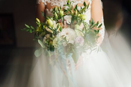Beautiful bride is holding a wedding colorful bouquet.の写真素材