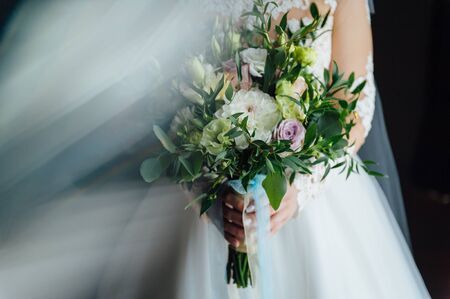 Beautiful bride is holding a wedding colorful bouquet.の写真素材