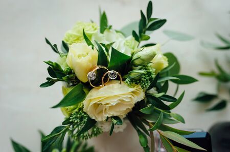 Gold wedding rings with flowers around-close-up. sunny day.の写真素材