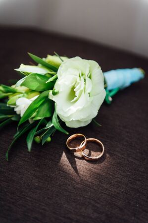 Gold wedding rings with flowers around-close-up. sunny dayの写真素材