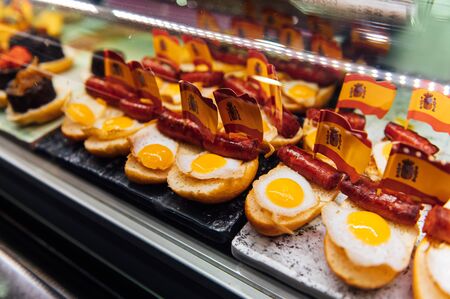 Spanish burger with omelet and souvenir flag of Spain in the market of San Miguel.の写真素材