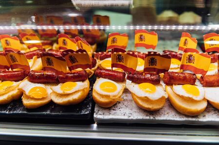 Spanish burger with omelet and souvenir flag of Spain in the market of San Miguel.の写真素材