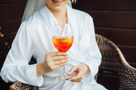 sexy woman holding a glass with aperol cocktail and smiling in the sunの写真素材