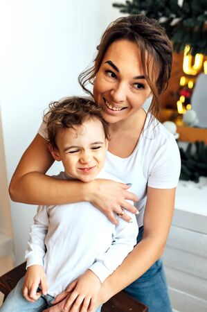beautiful mother hugs her son on the couchの写真素材
