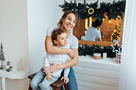 beautiful mother hugs her son on the couchの写真素材