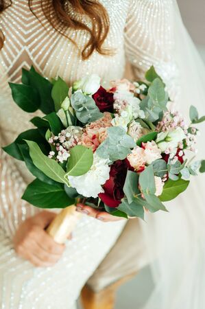 Beautiful bride is holding a wedding colorful bouquet.の写真素材