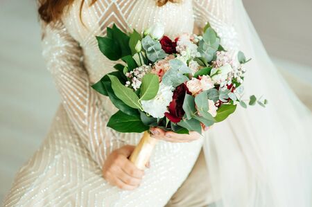 Beautiful bride is holding a wedding colorful bouquet.の写真素材