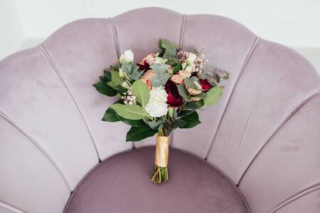 Wedding bouquet of flowers on a vintage white armchairの写真素材