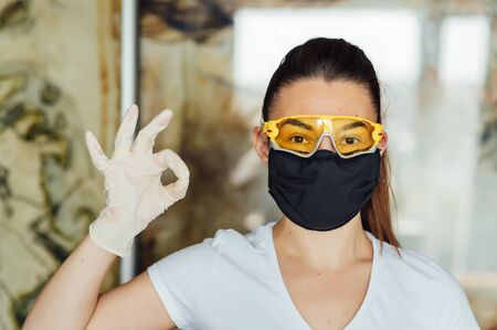 Cute girl shows how to wear a protective mask and glassesの写真素材