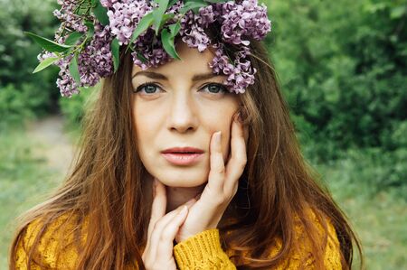 Beautiful woman with lilac flower wreath. Girl in a wreath of lilac in the spring.の写真素材