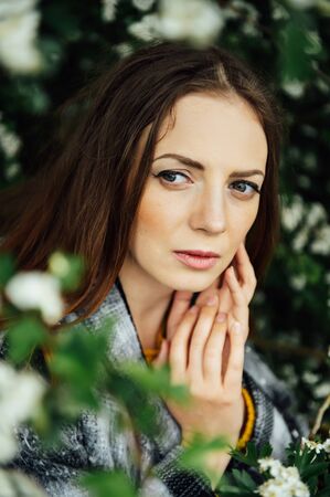 Outdoor fashion photo of beautiful young woman surrounded by flowers.の写真素材