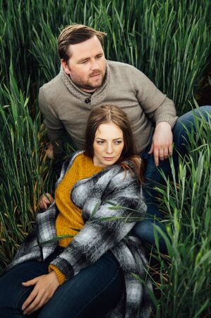 Beautiful hugging couple in love in an early wheat fieldの写真素材