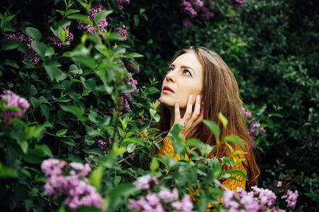 Outdoor fashion photo of beautiful young woman surrounded by flowers.の写真素材