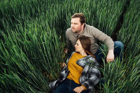 Beautiful hugging couple in love in an early wheat fieldの写真素材