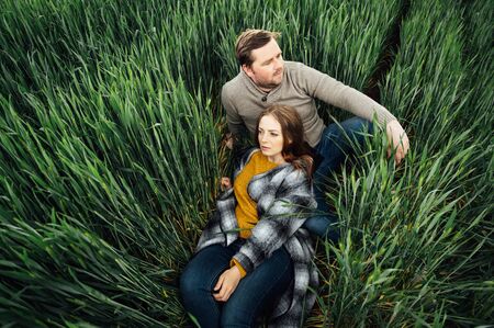 Beautiful hugging couple in love in an early wheat fieldの写真素材