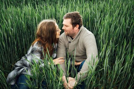 Beautiful hugging couple in love in an early wheat fieldの写真素材