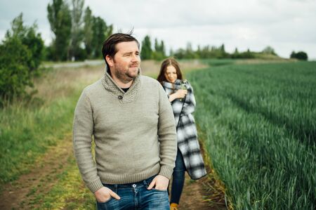 Young lovers walk near the field of early wheat. Hug and have funの写真素材