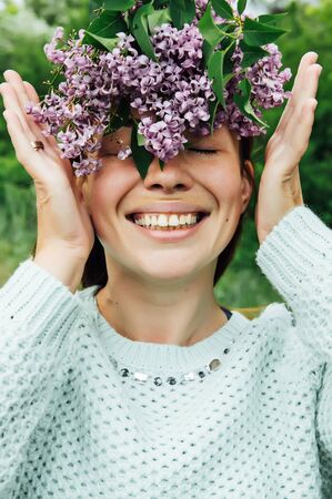 Beautiful woman with lilac flower wreath.の写真素材