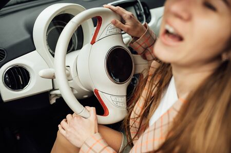 Gorgeous girl with long hair sitting in a red electric carの写真素材